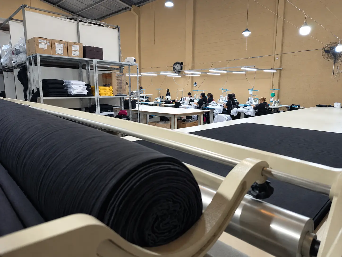 Rolo de meia malha preta e estrutura de produção da VCSTILO